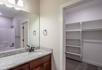 A bathroom with a sink, mirror, and a closet at Cedar Crest Apartments, Arkansas, 72730